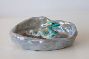 Ceramic dish with a blue dragon figurine on a white background