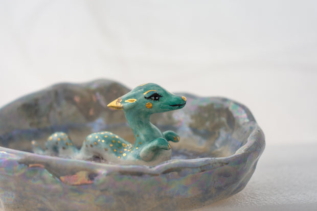 Ceramic dish with a blue dragon figurine on a white background