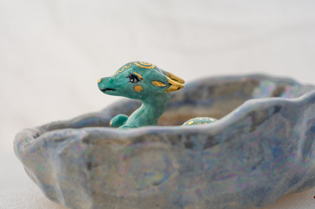 Ceramic dish with a blue dragon figurine on a white background