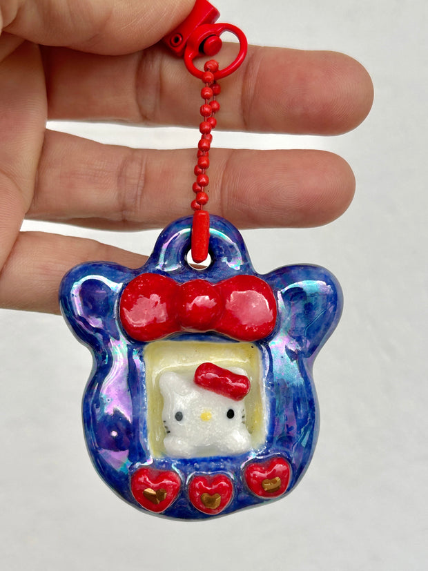 Iridescent hanging ceramic keychain with Hello Kitty in the center 