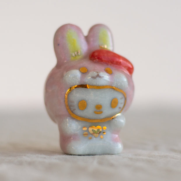 Ceramic rabbit figurine with gold accents on a light background