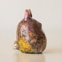 Ceramic figurine in the shape of Totoro, with a raku fired glaze that makes it iridescent over a gold base.