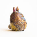 Ceramic figurine in the shape of Totoro, with a raku fired glaze that makes it iridescent over a gold base.