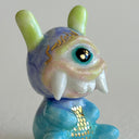 Small collection of sculptures: several buildings and a cyclops character with large rounded teeth.