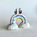 Small ceramic sculpture of a rainbow with clouds on the ends and 2 tiny foxes standing at the top, facing each other as though they are getting married.