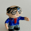 Small collection of sculptures: a business man with glasses, the Tokyo tower, small buildings and a red bridge.