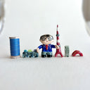 Small collection of sculptures: a business man with glasses, the Tokyo tower, small buildings and a red bridge.