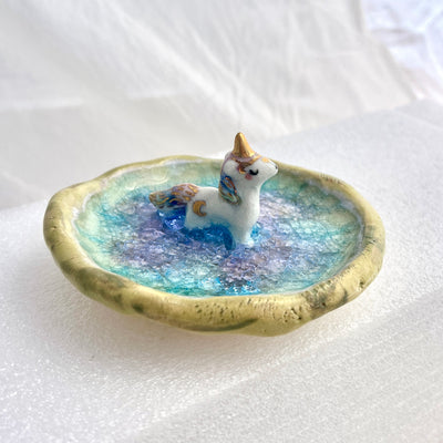 Small ceramic dish with a unicorn standing in the middle of it.