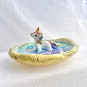 Small ceramic dish with a unicorn standing in the middle of it.
