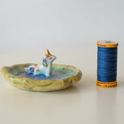 Small ceramic dish with a unicorn standing in the middle of it.
