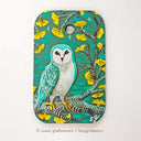 Painting of a turquoise colored owl standing on a branch of a gingko tree with yellow leaves. Background is teal blue.