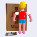 Soft vinyl figure of a tall office woman with short blonde hair, a bright pink vest and blue skirt.