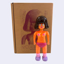 Vinyl toy figure of a topless woman with glittery orange skin and pink underwear.