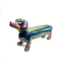 An iridescent dachshund-shaped sculpture with a metallic, rainbow-like finish on a plain white background.