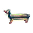 An iridescent dachshund-shaped sculpture with a metallic, rainbow-like finish on a plain white background.