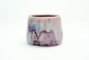 Glossy ceramic cup with a deep reddish purple to light blue gradient coloring with gold sparkles on it. 