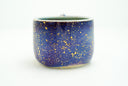 Glossy ceramic handle mug with a dark blue to light blue gradient coloring with gold sparkles on it. 