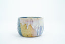 Short ceramic bowl with a blue and yellow multicolor glaze and golden splatters.