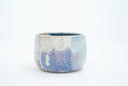 Short ceramic bowl with a blue and purple multicolor glaze and golden splatters.