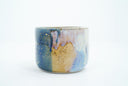 Short ceramic bowl with a blue and yellow multicolor glaze and golden splatters.