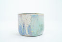 Short ceramic bowl with a blue multicolor glaze and golden splatters.
