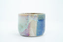 Short ceramic bowl with a blue multicolor glaze and golden splatters.