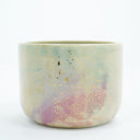 Short ceramic bowl with a light green and light purple multicolor glaze and golden splatters.