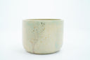 Short ceramic bowl with a light green and light purple multicolor glaze and golden splatters.