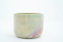 Short ceramic bowl with a light green and light purple multicolor glaze and golden splatters.