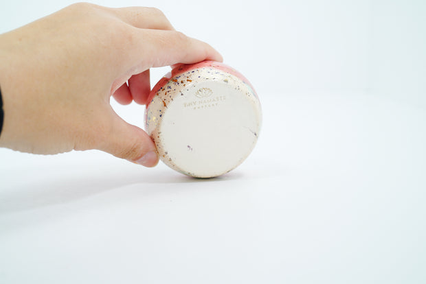 Underside of ceramic pot with artist's signature stamped into the clay.
