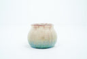 Small ceramic pot with a gradient of light brown to blue and gold speckles.
