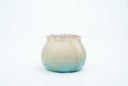 Small ceramic pot with a gradient of light brown to blue and gold speckles.