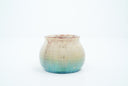 Small ceramic pot with a gradient of light brown to blue and gold speckles.