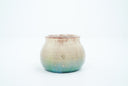 Small ceramic pot with a gradient of light brown to blue and gold speckles.