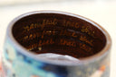 Inside view of mug with 3 rows of gold text that reads "manifest that shit"
