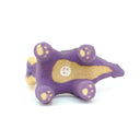 Ceramic sculpture of a purple skunk, done in a cartoon style with large bulbous black eyes and a very small, skinny head.