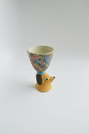 Ceramic floral cup with a brown floppy eared dog as a handle.