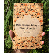 Zine cover that reads "Defectivepudding's Sketchbook" on a patterned background of ghosts, mushrooms and witch's hats.