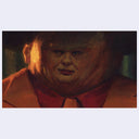 Painting of a film still from Dick Tracy of a man with a very large fat head and small face.