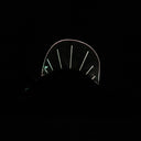 Wooden sculpture of a black dinosaur, flat mostly and emphasizing its silhouette.  Atop its back is a rounded plastic sheet with a line of lights, illuminating it and the interior of its mouth.