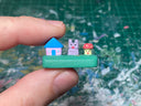 Small sculpture with a house, a purple bunny and a mushroom.