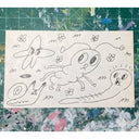 Ink doodles on an index card of a frog, snail and caterpillar all with human-like facial expressions.