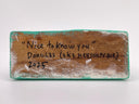 Wooden block with engraved text on a white background
