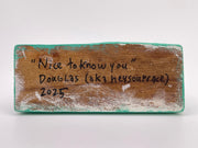 Wooden block with engraved text on a white background