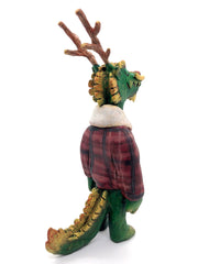 Sculpture of a green dragon with wooden antlers and yellow/gold color accents. It stands on 2 legs like a human and wears a red sherpa flannel jacket.