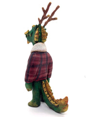 Sculpture of a green dragon with wooden antlers and yellow/gold color accents. It stands on 2 legs like a human and wears a red sherpa flannel jacket.