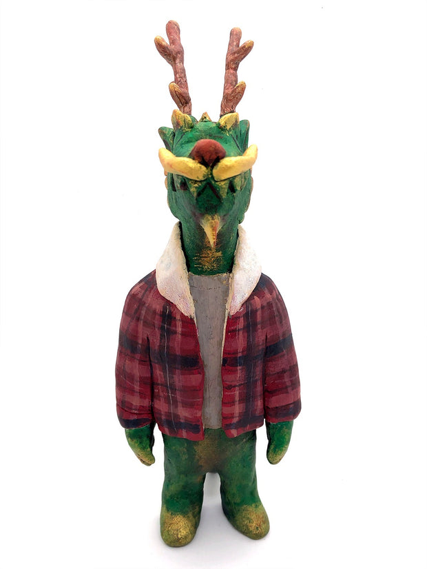 Sculpture of a green dragon with wooden antlers and yellow/gold color accents. It stands on 2 legs like a human and wears a red sherpa flannel jacket.