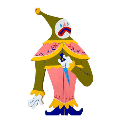 Die cut painted wooden sculpture of a stylized clown, with a white painted face. It wears green and pink clothing, with frills and painted details and a tall hat with a bell atop. It holds a sharp dagger and frowns.