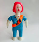 Toy figure with red hair and blue outfit on a light gray background