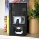 Artwork on a VHS tape of a dog looking at an old style TV, which has a very static-y screen. 